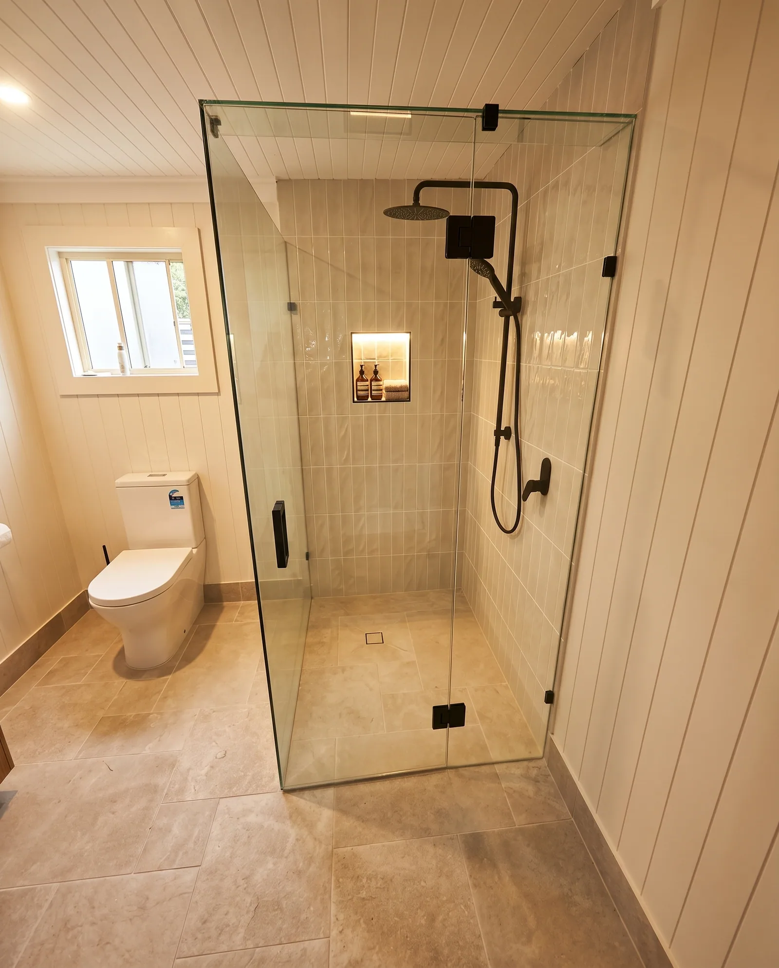 Minimal white bathroom with frameless shower